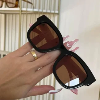 En Trendstore te presentamos los lentes de sol Gucci GG0998S 005, un modelo icónico que combina diseño fashion, calidad italiana y el sello inconfundible de Gucci. Fabricados en Italia, estos lentes destacan por su marco de acetato en color negro brillante (Shiny Black), aportando una estética sofisticada y atemporal. Su forma cuadrada con marco completo es ideal para rostros ovalados y redondos, entregando equilibrio y un look moderno que se adapta tanto a estilos clásicos como más audaces. Los cristales de nylon en tono café no solo complementan perfectamente el diseño, sino que también brindan una experiencia visual cómoda para el uso diario. Pensados para mujeres que buscan accesorios de alto impacto y durabilidad, los Gucci GG0998S son un must-have de temporada y una inversión segura en estilo. Cada detalle refleja la excelencia de la marca y su enfoque en la moda de lujo contemporánea. Disponibles en Trendstore Chile, con garantía de originalidad y una selección curada de marcas internacionales para mujeres que buscan diferenciarse con elegancia.