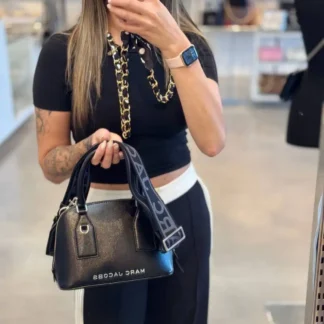 La Marc Jacobs Small Leather Dome Satchel Crossbody Bag en color negro destaca por su diseño sofisticado y femenino, ideal para acompañarte en distintas ocasiones. Confeccionada en cuero de alta calidad, presenta una estructura tipo domo que mantiene su forma y aporta un look elegante y moderno. Cuenta con cierre superior con cremallera, un bolsillo interior con cierre para organizar tus objetos y el logo Marc Jacobs en el frente, que aporta identidad al diseño. Gracias a su formato 2 en 1, puede usarse como tote con asa superior o como crossbody mediante su correa ajustable y desmontable. Sus dimensiones de 24 cm de ancho x 10 cm de profundidad x 17 cm de alto la hacen ideal para llevar tus esenciales diarios de forma cómoda y ordenada. Un bolso versátil, funcional y atemporal para uso diario o salidas especiales. Disponible en Trendstore Chile, con envío a todo el país y garantía de originalidad.