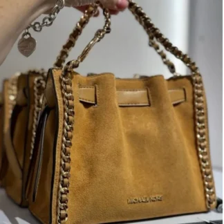 El bolso crossbody Michael Kors Mina es un básico atemporal pensado para acompañarte todos los días. Está confeccionado en ante de cuero suave proveniente de curtidurías que cumplen altos estándares medioambientales, combinando elegancia, calidad y durabilidad en una pieza versátil y femenina. Su diseño compacto y estructurado mide aproximadamente 21 cm de ancho, 17,1 cm de alto y 8,9 cm de profundidad, un tamaño ideal para llevar lo esencial sin perder comodidad. La correa ajustable permite un largo entre 50,8 cm y 60,3 cm, lo que facilita usarlo al hombro o cruzado según tu estilo y ocasión. Los detalles de cadena en tono dorado aportan un toque glamoroso y elevan el diseño, convirtiéndolo en una excelente opción tanto para looks de día como para salidas nocturnas. En su interior, el bolso cuenta con forro de poliéster y un bolsillo trasero que ayuda a mantener tus pertenencias organizadas. El cierre con botón a presión mantiene el contenido seguro sin perder practicidad, mientras que su estética atemporal asegura que sea un bolso que podrás usar temporada tras temporada. En Trendstore Chile seleccionamos carteras originales Michael Kors pensadas para mujeres que buscan diseño, funcionalidad y estilo premium. El modelo Mina es una elección segura y elegante para complementar cualquier outfit. Disponible en Trendstore.cl con despacho a todo Chile y todos los métodos de pago.