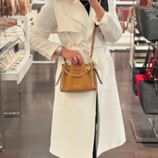 El bolso crossbody Michael Kors Mina es un básico atemporal pensado para acompañarte todos los días. Está confeccionado en ante de cuero suave proveniente de curtidurías que cumplen altos estándares medioambientales, combinando elegancia, calidad y durabilidad en una pieza versátil y femenina. Su diseño compacto y estructurado mide aproximadamente 21 cm de ancho, 17,1 cm de alto y 8,9 cm de profundidad, un tamaño ideal para llevar lo esencial sin perder comodidad. La correa ajustable permite un largo entre 50,8 cm y 60,3 cm, lo que facilita usarlo al hombro o cruzado según tu estilo y ocasión. Los detalles de cadena en tono dorado aportan un toque glamoroso y elevan el diseño, convirtiéndolo en una excelente opción tanto para looks de día como para salidas nocturnas. En su interior, el bolso cuenta con forro de poliéster y un bolsillo trasero que ayuda a mantener tus pertenencias organizadas. El cierre con botón a presión mantiene el contenido seguro sin perder practicidad, mientras que su estética atemporal asegura que sea un bolso que podrás usar temporada tras temporada. En Trendstore Chile seleccionamos carteras originales Michael Kors pensadas para mujeres que buscan diseño, funcionalidad y estilo premium. El modelo Mina es una elección segura y elegante para complementar cualquier outfit. Disponible en Trendstore.cl con despacho a todo Chile y todos los métodos de pago.