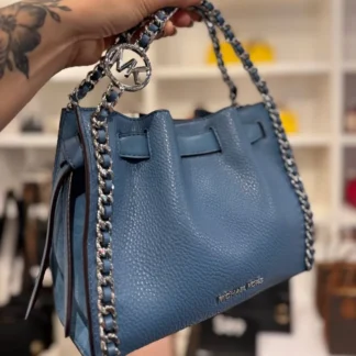 Descripción larga La bandolera Mina pequeña convertible con cadena de Michael Kors combina diseño moderno y funcionalidad en un formato compacto y elegante. Confeccionada en una resistente mezcla de poliuretano con ribetes en piel, es ideal para el uso diario o para complementar looks más sofisticados. Su diseño estructurado se realza con apliques metálicos en tono plateado y una silueta versátil que permite llevarla cómodamente como bandolera gracias a su tira extraíble. A pesar de su tamaño reducido, ofrece el espacio justo para llevar tus esenciales de forma organizada. Sus dimensiones de 8.25 pulgadas de ancho, 6.75 pulgadas de alto y 3.5 pulgadas de profundidad la convierten en una opción práctica y liviana, perfecta para quienes buscan estilo sin sacrificar comodidad. El interior cuenta con un bolsillo trasero que facilita el orden, mientras que el cierre con botón a presión mantiene tus pertenencias seguras. Un modelo importado, ideal para quienes buscan un accesorio atemporal, funcional y con el sello distintivo de Michael Kors. Detalles • Bandolera • Mezcla de poliuretano • 60% poliuretano / 20% algodón / 20% poliéster • Ribete 1: 100% piel • Ribete 2: 60% poliuretano / 20% algodón / 20% poliéster • Apliques en tono plateado • Medidas: 8.25" (ancho) x 6.75" (alto) x 3.5" (profundidad) • Detalles exteriores: tira extraíble • Detalles interiores: bolsillo trasero • Forro: 100% poliéster • Cierre con botón a presión • Funda protectora no incluida • Producto importado • N.º de producto: 35F5S4MC1V