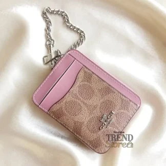 En Trendstore Chile te presentamos la Zip Card Case de Coach, un accesorio compacto y funcional que combina diseño elegante y practicidad. Confeccionada en Signature coated canvas, esta billetera ofrece resistencia y un acabado premium en un formato ultracompacto, ideal para caber en bolsos pequeños o incluso en el bolsillo. Cuenta con un bolsillo abierto, un compartimento con cremallera y dos ranuras para tarjetas, además de una ventana para identificación, manteniendo tus esenciales organizados y accesibles. Su correa de cadena con clip tipo dogleash añade un detalle metálico brillante y permite llevarla cómodamente en la muñeca. Medidas aproximadas: Largo: 7,6 cm Alto: 10,8 cm Ancho: 1,9 cm Materiales: Signature coated canvas Correa de cadena metálica Características principales: Modelo: Zip Card Case Style Number: CW883 Bolsillo abierto Compartimento con cremallera Dos ranuras para tarjetas Ventana para identificación Correa de cadena tipo muñequera Público: Mujer Un accesorio original Coach, seleccionado por Trendstore para mujeres que buscan una billetera compacta, funcional y de moda premium, disponible para venta en Chile.