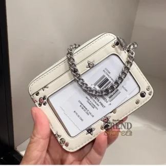 En Trendstore Chile te presentamos la Zip Card Case de Coach, un accesorio compacto y funcional que combina diseño elegante y practicidad. Confeccionada en Signature coated canvas, esta billetera ofrece resistencia y un acabado premium en un formato ultracompacto, ideal para caber en bolsos pequeños o incluso en el bolsillo. Cuenta con un bolsillo abierto, un compartimento con cremallera y dos ranuras para tarjetas, además de una ventana para identificación, manteniendo tus esenciales organizados y accesibles. Su correa de cadena con clip tipo dogleash añade un detalle metálico brillante y permite llevarla cómodamente en la muñeca. Medidas aproximadas: Largo: 7,6 cm Alto: 10,8 cm Ancho: 1,9 cm Materiales: Signature coated canvas Correa de cadena metálica Características principales: Modelo: Zip Card Case Style Number: CW883 Bolsillo abierto Compartimento con cremallera Dos ranuras para tarjetas Ventana para identificación Correa de cadena tipo muñequera Público: Mujer Un accesorio original Coach, seleccionado por Trendstore para mujeres que buscan una billetera compacta, funcional y de moda premium, disponible para venta en Chile.