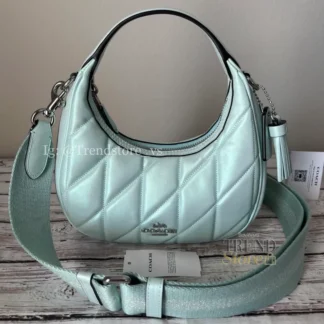 En Trendstore Chile te presentamos este bolso Coach confeccionado en cuero suave perlado, un material premium que combina suavidad, durabilidad y un acabado elegante. Su diseño práctico y moderno lo hace ideal para mujeres que buscan estilo y funcionalidad en un solo accesorio. Cuenta con un cierre superior de cremallera que mantiene tus pertenencias seguras, mientras que su interior forrado en tela incluye un bolsillo con cremallera para organizar tus esenciales. Las asas permiten llevarlo de manera cómoda en la mano, y la correa desmontable con caída de 59,7 cm ofrece la opción de usarlo al hombro o cruzado tipo crossbody según tu estilo. Medidas aproximadas: Largo: 19,7 cm Alto: 10,2 cm Ancho: 6,4 cm Caída de asas: 12,7 cm Caída de correa desmontable: 59,7 cm Materiales: Cuero suave perlado Forro interior de tela Características