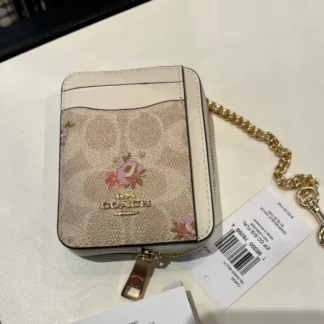 En Trendstore Chile te presentamos la Zip Card Case de Coach, un accesorio compacto y funcional que combina diseño elegante y practicidad. Confeccionada en Signature coated canvas, esta billetera ofrece resistencia y un acabado premium en un formato ultracompacto, ideal para caber en bolsos pequeños o incluso en el bolsillo. Cuenta con un bolsillo abierto, un compartimento con cremallera y dos ranuras para tarjetas, además de una ventana para identificación, manteniendo tus esenciales organizados y accesibles. Su correa de cadena con clip tipo dogleash añade un detalle metálico brillante y permite llevarla cómodamente en la muñeca. Medidas aproximadas: Largo: 7,6 cm Alto: 10,8 cm Ancho: 1,9 cm Materiales: Signature coated canvas Correa de cadena metálica Características principales: Modelo: Zip Card Case Style Number: CW883 Bolsillo abierto Compartimento con cremallera Dos ranuras para tarjetas Ventana para identificación Correa de cadena tipo muñequera Público: Mujer Un accesorio original Coach, seleccionado por Trendstore para mujeres que buscan una billetera compacta, funcional y de moda premium, disponible para venta en Chile.