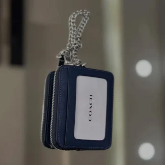 En Trendstore Chile te presentamos la Zip Card Case de Coach, un accesorio compacto y funcional que combina diseño elegante y practicidad. Confeccionada en Signature coated canvas, esta billetera ofrece resistencia y un acabado premium en un formato ultracompacto, ideal para caber en bolsos pequeños o incluso en el bolsillo. Cuenta con un bolsillo abierto, un compartimento con cremallera y dos ranuras para tarjetas, además de una ventana para identificación, manteniendo tus esenciales organizados y accesibles. Su correa de cadena con clip tipo dogleash añade un detalle metálico brillante y permite llevarla cómodamente en la muñeca. Medidas aproximadas: Largo: 7,6 cm Alto: 10,8 cm Ancho: 1,9 cm Materiales: Signature coated canvas Correa de cadena metálica Características principales: Modelo: Zip Card Case Style Number: CW883 Bolsillo abierto Compartimento con cremallera Dos ranuras para tarjetas Ventana para identificación Correa de cadena tipo muñequera Público: Mujer Un accesorio original Coach, seleccionado por Trendstore para mujeres que buscan una billetera compacta, funcional y de moda premium, disponible para venta en Chile.
