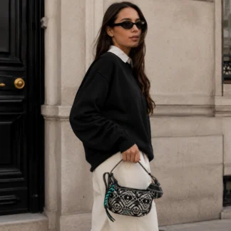 Bolso Zadig & Voltaire Le Cecilia XS Jacquard Negro con Correa Ajustable El bolso Le Cecilia XS Jacquard de Zadig & Voltaire es una pieza icónica que refleja el estilo casual chic y la personalidad urbana de la marca. Diseñado por Cecilia Bönström, este modelo está pensado para mujeres seguras, activas y con un estilo propio, que buscan un bolso versátil y con carácter. Confeccionado en jacquard negro con motivos folklóricos en contraste, destaca por su diseño visual y su textura. Su correa ajustable con ribete bordado permite alargar el asa con un solo movimiento, transformando la forma de llevarlo y revelando su espíritu rockero gracias a la hebilla metálica en forma de C. Puede usarse como bolso de mano, al hombro o cruzado, adaptándose fácilmente a distintos momentos del día. Cuenta con cierre de cremallera, tirador con cadena turquesa en contraste y forro interior de microfibra que aporta un acabado suave y cuidado. Su tamaño XS es ideal para llevar lo esencial sin perder presencia ni estilo. Detalles del producto: – Marca: Zadig & Voltaire – Modelo: Le Cecilia XS Jacquard Folk – Color: Negro – Material: Jacquard – Composición: 57% algodón, 36% poliéster, 4% acrílico, 3% otras fibras – Correa: Ajustable con ribete bordado – Hebilla: Metálica en forma de C – Cierre: Cremallera – Forro: Microfibra – Hecho en Italia – Código de producto: LWBA02201 Medidas aproximadas: – Ancho: 15 cm – Alto: 22 cm – Fondo: 11 cm – Largo de correa: ajustable entre 11 cm y 50 cm Producto original Zadig & Voltaire, cuidadosamente seleccionado por Trendstore Chile para mujeres que buscan moda premium con diseño, identidad y versatilidad, disponible para venta en Chile.
