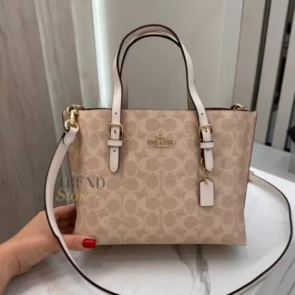 La Coach Mollie Tote Bag 25 es una cartera versátil y funcional, perfecta para acompañarte en tu rutina diaria. Confeccionada en lona revestida Signature de Coach, combina durabilidad, diseño icónico y un estilo atemporal que se adapta tanto a looks casuales como más formales. Su interior es amplio para su tamaño y permite llevar desde tablets pequeñas hasta tus esenciales diarios, manteniéndolos organizados gracias a sus compartimentos laterales abiertos y a su bolsillo central con cierre superior que brinda mayor seguridad. El forro de tela aporta un acabado prolijo y resistente. Incluye asas superiores para llevarla cómodamente en la mano o al hombro, además de una correa desmontable que permite usarla como shoulder bag o crossbody, adaptándose fácilmente a distintos momentos del día. Medidas del modelo: Largo: 24,8 cm Alto: 19 cm Ancho: 12,1 cm Detalles del producto: Marca: Coach Modelo: Mollie Tote 25 Style Number: CV965 Material: Lona revestida Signature Forro: Tela Cierre: Cremallera superior Compartimentos: laterales abiertos + bolsillo central con cierre Asas: caída de 12 cm Correa: desmontable, caída de 56 cm Estilo: Tote mediana / uso diario En Trendstore Chile encuentras carteras Coach 100% originales, con compra segura, atención cercana y envíos a todo Chile. Un modelo práctico, elegante y pensado para acompañarte todos los días.