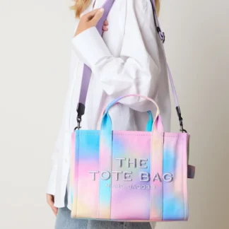 Bolso Marc Jacobs confeccionado en canvas, práctico y versátil para el uso diario. Su diseño amplio permite llevar teléfono y tablet con comodidad, manteniendo una silueta estructurada y elegante. Incluye cierre superior con cierre y un interior funcional con bolsillos que facilitan la organización. Incorpora manillas cortas y una correa de hombro desmontable y ajustable, ideal para usar al hombro o cruzado según tu estilo. Un modelo atemporal que combina funcionalidad y diseño, fiel al ADN urbano y sofisticado de Marc Jacobs. Detalles • Bolso de hombro / crossbody • Canvas • Herrajes en negro y gun metal • Cierre con cierre • 1 compartimento principal • 1 bolsillo interior con cierre • 2 bolsillos interiores abiertos • Espacio para teléfono y tablet • Correa desmontable y ajustable Medidas • Ancho: 33 cm • Alto: 27 cm • Profundidad: 15 cm • Altura manillas: 11 cm • Largo correa: 85 – 130 cm