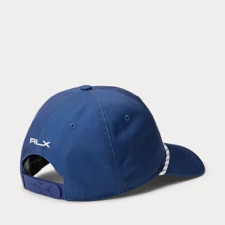 Gorra deportiva de Polo Ralph Lauren de la línea RLX, diseñada para ofrecer estilo y rendimiento en un solo accesorio. Su construcción de cinco paneles brinda un ajuste cómodo, mientras que su diseño técnico incorpora detalles pensados para el uso activo. Destaca por el icónico Polo Bear junto al logo “RLX” bordado en la parte frontal, complementado con visera curva con costuras y detalle de cuerda decorativa. Incorpora ojales bordados para ventilación y una banda interior de malla que ayuda a absorber la humedad, manteniendo frescura durante todo el día. La correa trasera ajustable con broche y logo RLX permite un calce seguro y personalizado. Detalles • Gorra deportiva / lifestyle • Construcción de cinco paneles • Visera curva con costuras • Detalle de cuerda en la visera • Ojales bordados para ventilación • Banda interior de malla absorbente (moisture-wicking) • Polo Bear y logo “RLX” bordados al frente • Logo “RLX” bordado en la parte trasera • Correa ajustable con broche