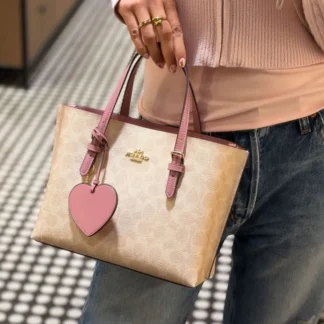 Cartera Coach Mollie Tote 25 Signature con charm corazón original Trendstore Chile compra segura Coach Mollie Tote 25 bolso mujer vista frontal lona Signature envío a todo Chile Detalle charm corazón cartera Coach Signature diseño femenino original Chile Cartera Coach Mollie Tote 25 con correa crossbody desmontable original Trendstore Chile Vista lateral bolso Coach Mollie Tote tamaño ideal uso diario mujer Chile Interior cartera Coach Mollie Tote compartimentos laterales y cierre cremallera original Cartera Coach Signature elegante con charm corazón diseño premium mujer Chile
