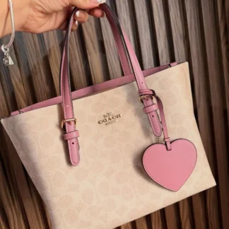 Cartera Coach Mollie Tote 25 Signature con charm corazón original Trendstore Chile compra segura Coach Mollie Tote 25 bolso mujer vista frontal lona Signature envío a todo Chile Detalle charm corazón cartera Coach Signature diseño femenino original Chile Cartera Coach Mollie Tote 25 con correa crossbody desmontable original Trendstore Chile Vista lateral bolso Coach Mollie Tote tamaño ideal uso diario mujer Chile Interior cartera Coach Mollie Tote compartimentos laterales y cierre cremallera original Cartera Coach Signature elegante con charm corazón diseño premium mujer Chile