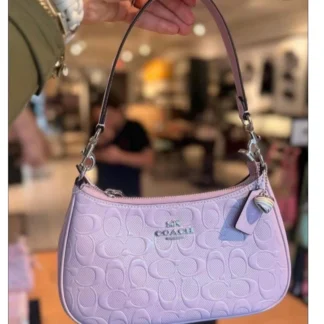 Cartera Coach Teri charol light violet heart charm original Trendstore Chile compra segura Coach Teri shoulder bag violeta brillante mujer envío a todo Chile Detalle cuero charol Signature con charm corazón Coach original Chile Bolso Coach Teri crossbody mujer elegante Trendstore Chile Vista lateral cartera Coach Teri violeta mujer original Chile Interior bolso Coach Teri compartimento multifunción Trendstore Chile Shoulder bag Coach mujer original envío seguro Chile
