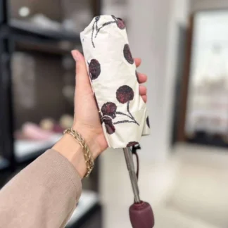 El paraguas mini de Coach con cherry print es el accesorio ideal para mujeres que buscan funcionalidad con un toque distintivo. Disponible en Trendstore Chile, este modelo combina diseño compacto, protección y estilo en un solo producto. Confeccionado en nylon estampado, destaca por su diseño de cerezas que aporta un aire fresco, femenino y moderno. Su formato compacto permite llevarlo fácilmente en la cartera o bolso, siendo perfecto para el uso diario. Cuenta con protección UV del 99%, lo que lo hace ideal tanto para días soleados como lluviosos, ofreciendo versatilidad durante todo el año. Además, incluye correa de muñeca que facilita su transporte. Detalles del producto: Tipo: paraguas mini compacto mujer Material: nylon estampado Protección: 99% UV Diseño: cherry print (estampado de cerezas) Correa de muñeca incorporada Uso: lluvia y sol Código de producto: CDF36 En Trendstore Chile ofrecemos productos 100% originales, con compra segura y envíos a todo Chile.
