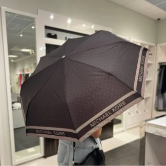 El paraguas de Michael Kors es el accesorio ideal para enfrentar días lluviosos con estilo y funcionalidad. Disponible en Trendstore Chile, este modelo combina diseño icónico, materiales responsables y practicidad en un formato compacto. Está confeccionado en 100% poliéster reciclado con estampado de logotipo, ofreciendo resistencia y compromiso con el medio ambiente. Su diseño incorpora ribetes deportivos que aportan un look moderno, mientras que los apliques en tono dorado elevan su estética con un acabado sofisticado. Gracias a su tamaño compacto, es perfecto para llevar dentro de tu bolso tote o cartera, asegurando que siempre estés preparada ante cambios de clima sin sacrificar estilo. Incluye cierre de velcro y correa de muñeca, facilitando su transporte y uso diario. Detalles del producto: Tipo: paraguas compacto mujer Material: 100% poliéster reciclado Ribete: 100% polipropileno Medidas: 31,1 cm (ancho) x 5,1 cm (alto) x 5,1 cm (profundidad) Estampado de logotipo Michael Kors Apliques en tono dorado Cierre con velcro Correa de muñeca Diseño compacto y portátil No incluye funda protectora Código de producto: 35F3GTFN4B En Trendstore Chile ofrecemos productos 100% originales, con compra segura y envíos a todo Chile.