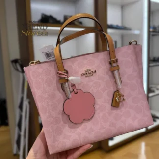 Cartera Coach Molly Tote 25 lona Signature original con charm floral Trendstore Chile compra segura Coach Molly Tote 25 bolso mujer vista frontal diseño Signature original envío a todo Chile Detalle lona Signature y cuero vachetta cartera Coach Molly Tote 25 original Chile Cartera Coach Molly Tote 25 con correa larga desmontable uso hombro y cruzado Trendstore Chile Interior cartera Coach Molly Tote 25 compartimento central cierre cremallera original Chile Vista lateral bolso Coach Molly Tote 25 tamaño ideal uso diario mujer Trendstore Chile Cartera Coach Signature con charm floral diseño elegante premium original Chile