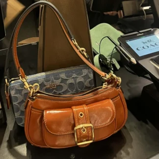 La cartera Ashton Mini Shoulder Bag de Coach es una pieza moderna, compacta y sofisticada, ideal para mujeres que buscan un bolso pequeño con estilo único. Disponible en Trendstore Chile, este modelo en tono light violet destaca por su acabado suave y femenino.