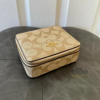 El Coach Large Jewelry Box en Signature Canvas es un accesorio sofisticado y funcional, ideal para organizar tus joyas con elegancia. Disponible en Trendstore Chile, este modelo combina el diseño icónico de la marca con una estructura compacta y práctica. Confeccionado en lona recubierta tipo PVC con estampado Signature, ofrece resistencia, durabilidad y fácil limpieza. Su formato compacto lo hace perfecto tanto para uso diario como para llevar en viajes, manteniendo tus accesorios protegidos y organizados. Cuenta con cierre superior con cremallera para mayor seguridad. En su interior, incluye múltiples compartimentos diseñados para distintas piezas: espacio para anillos, espejo integrado y compartimentos libres para guardar collares, aros u otros accesorios. Su diseño elegante lo convierte también en una excelente opción de regalo. Detalles del producto: Tipo: joyero / organizador de joyas Material: lona recubierta PVC con estampado Signature Medidas: 12,7 cm (largo) x 10,2 cm (alto) x 5,1 cm (profundidad) Cierre superior con cremallera Interior: 7 espacios para anillos Incluye espejo interior 3 compartimentos libres Diseño compacto y portátil En Trendstore Chile ofrecemos productos 100% originales, con compra segura y envíos a todo Chile.