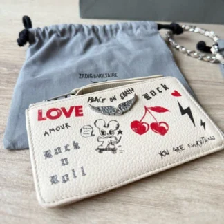 El ZADIG & VOLTAIRE ZV CARD LOVE TAG FLASH PORTATARJETAS DE CUERO BLANCO combina diseño contemporáneo, funcionalidad y el estilo inconfundible de la firma parisina en un accesorio compacto ideal para el uso diario. Confeccionado en 100% cuero premium, este portatarjetas destaca por su elegante acabado en color blanco con el exclusivo diseño Love Tag Flash, un estampado que refleja la actitud moderna y el espíritu rock chic característico de Zadig & Voltaire. Su formato delgado permite transportarlo cómodamente en bolsos pequeños, clutch o incluso en el bolsillo, convirtiéndose en una excelente alternativa para quienes prefieren llevar únicamente lo esencial. Su interior está diseñado para mantener una organización práctica, incorporando cuatro compartimentos para tarjetas, un bolsillo plano y un compartimento con cierre de cremallera ideal para monedas, billetes doblados o pequeños objetos personales. El cierre superior con cremallera aporta mayor seguridad durante el uso diario. Gracias a su diseño compacto y sofisticado, este accesorio resulta perfecto para complementar cualquier bolso o utilizarlo de forma independiente en salidas donde se busca comodidad sin renunciar al estilo. En Trendstore Chile seleccionamos productos originales de las marcas más exclusivas de Europa y Estados Unidos para ofrecer accesorios auténticos, premium y difíciles de encontrar en Chile. El Zadig & Voltaire ZV Card Love Tag Flash es una pieza funcional y elegante que refleja el diseño contemporáneo de la marca francesa. Medidas: • Largo: 13,5 cm • Alto: 8 cm • Ancho: 1 cm Material: • 100% cuero premium Características destacadas: • Diseño Love Tag Flash exclusivo • Color blanco con estampado • Cierre superior con cremallera • 4 compartimentos para tarjetas • 1 bolsillo plano interior • 1 bolsillo interior con cierre • Diseño compacto y ligero • Producto original Zadig & Voltaire SEO PARA IMÁGENES • Zadig & Voltaire ZV Card Love Tag Flash original disponible en Trendstore Chile • Portatarjetas Zadig & Voltaire blanco de cuero vista frontal compra segura Chile • Billetera porta tarjetas Love Tag Flash original Zadig & Voltaire • Detalle estampado Love Tag Flash cuero premium Trendstore Chile • Vista lateral portatarjetas Zadig & Voltaire blanco envío a todo Chile • Interior con compartimentos para tarjetas Zadig & Voltaire original • Portatarjetas de cuero premium Zadig & Voltaire exclusivo para mujer • ZV Card Love Tag Flash original disponible en Trendstore Chile