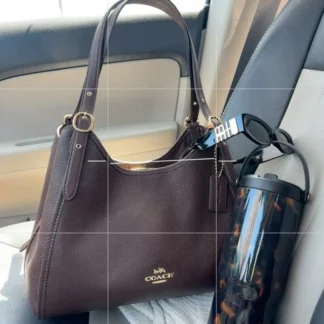 Coach Erin Shoulder Bag Maple original disponible en Trendstore Chile • Bolso Coach Erin Shoulder Bag cuero pebble color Maple vista frontal Chile • Detalle cuero Refined Pebble Leather Coach Erin Shoulder Bag original • Cartera Coach Maple con herrajes dorados compra segura Chile • Vista lateral Coach Erin Shoulder Bag premium para mujer Trendstore Chile • Interior organizado Coach Erin Shoulder Bag con compartimento central y bolsillos • Bolso Coach original de cuero pebble envío a todo Chile • Coach Erin Shoulder Bag color Maple exclusivo para mujer disponible en Trendstore Chile