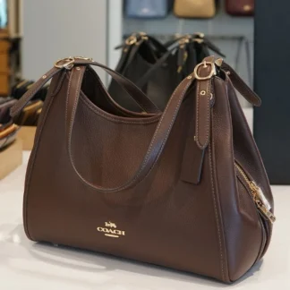 Coach Erin Shoulder Bag Maple original disponible en Trendstore Chile • Bolso Coach Erin Shoulder Bag cuero pebble color Maple vista frontal Chile • Detalle cuero Refined Pebble Leather Coach Erin Shoulder Bag original • Cartera Coach Maple con herrajes dorados compra segura Chile • Vista lateral Coach Erin Shoulder Bag premium para mujer Trendstore Chile • Interior organizado Coach Erin Shoulder Bag con compartimento central y bolsillos • Bolso Coach original de cuero pebble envío a todo Chile • Coach Erin Shoulder Bag color Maple exclusivo para mujer disponible en Trendstore Chile