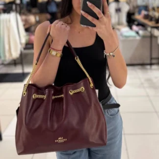 Coach Evelyn Shoulder Bag Gold Dark Wine original disponible en Trendstore Chile • Bolso Coach Evelyn Shoulder Bag cuero brillante vista frontal compra segura Chile • Detalle cuero shiny smooth leather Coach Evelyn Shoulder Bag original • Vista lateral Coach Evelyn Shoulder Bag Dark Wine premium para mujer • Interior con bolsillos multifuncionales Coach Evelyn Shoulder Bag Trendstore Chile • Bolso Coach original color Dark Wine envío a todo Chile • Textura cuero brillante Coach Evelyn Shoulder Bag exclusivo para mujer • Coach Evelyn Shoulder Bag premium elegante disponible en Trendstore Chile