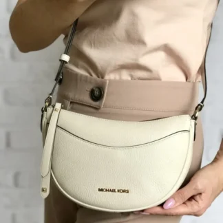 Cartera Michael Kors Dover Small Crossbody de cuero granulado color crema original disponible en Trendstore Chile. Vista frontal de la cartera Michael Kors Dover pequeña color crema con compra segura y envío a todo Chile. Detalle del cuero granulado premium de la Michael Kors Dover original disponible en Trendstore Chile. Vista lateral de la cartera Michael Kors Dover de media luna con correa ajustable y herrajes dorados. Interior de la cartera Michael Kors Dover Small con ranuras para tarjetas disponible en Trendstore Chile. Cartera Michael Kors Dover de cuero original para mujer con despacho a todo Chile desde Trendstore Chile. Detalle de la textura del cuero granulado y bolsillo exterior de la Michael Kors Dover original en Trendstore Chile. Cartera Michael Kors Dover Small Crossbody color crema original, compra segura y envío a todo Chile desde Trendstore Chile.