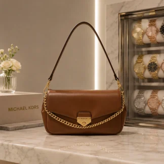 El MICHAEL KORS SOHO SMALL CONVERTIBLE SHOULDER BAG CAFÉ combina elegancia, funcionalidad y un diseño contemporáneo en un formato compacto pensado para acompañarte durante todo el día. Su silueta minimalista y los sofisticados herrajes en tono dorado reflejan el estilo moderno y atemporal que caracteriza a Michael Kors. Confeccionado en un material premium de alta resistencia con acabado similar al cuero, este bolso ofrece una excelente durabilidad y una apariencia refinada. Su elegante color café aporta calidez y versatilidad, convirtiéndose en un accesorio fácil de combinar con prendas neutras, denim, tonos tierra o looks más sofisticados durante cualquier temporada. Su diseño incorpora un compartimento principal con cierre de broche magnético que permite acceder fácilmente a tus pertenencias, además de un práctico bolsillo exterior trasero ideal para guardar tarjetas, documentos o billetes. Gracias a su tamaño compacto, ofrece espacio suficiente para transportar un teléfono de hasta 15,5 cm, un tarjetero, llaves, auriculares, bálsamo labial y otros esenciales del día. La correa ajustable y desmontable permite utilizarlo cómodamente al hombro o cruzado tipo crossbody, mientras que el asa superior brinda una alternativa elegante para llevarlo bajo el brazo durante reuniones, cenas o eventos especiales. En Trendstore Chile seleccionamos productos originales de las marcas más reconocidas internacionalmente para ofrecer accesorios exclusivos, auténticos y difíciles de encontrar en Chile. El Michael Kors Soho Small Convertible Shoulder Bag en color café es una excelente opción para quienes buscan un bolso compacto, sofisticado y versátil para cualquier ocasión. Medidas aproximadas: • Largo: 21,6 cm • Alto: 11,4 cm • Ancho: 6,4 cm • Caída del asa: 16,5 cm • Correa ajustable: de 52 cm a 61 cm Materiales: • Exterior: 53,5% poliuretano y 46,5% poliéster • Ribetes: 60% poliuretano, 22% poliéster y 18% algodón • Forro: 100% poliéster Características destacadas: • Diseño compacto y elegante • Color café • Herrajes metálicos color dorado • Cierre superior con broche magnético • Bolsillo exterior trasero • Asa para hombro • Correa ajustable y desmontable • Uso al hombro o cruzado • Ideal para llevar teléfono, tarjetas y objetos esenciales • Producto original Michael Kors SEO PARA IMÁGENES • Michael Kors Soho Small Convertible Shoulder Bag café original disponible en Trendstore Chile • Bolso Michael Kors Soho café vista frontal compra segura Chile • Cartera Michael Kors Soho pequeña color café con herrajes dorados • Detalle bolso Michael Kors Soho Convertible café premium Trendstore Chile • Vista lateral Michael Kors Soho Shoulder Bag color café envío a todo Chile • Bolso crossbody Michael Kors café para mujer original • Interior compacto Michael Kors Soho Small Convertible Bag premium • Michael Kors Soho Small Convertible Shoulder Bag café exclusivo disponible en Trendstore Chile