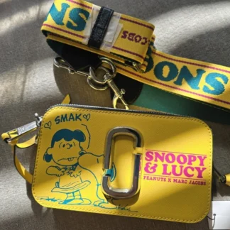 Cartera Marc Jacobs The Snapshot x Peanuts Snoopy & Lucy de cuero Saffiano original disponible en Trendstore Chile. Vista frontal de la cartera Marc Jacobs Snapshot Peanuts con estampado Snoopy y Lucy, compra segura en Chile. Detalle del estampado Snoopy & Lucy y logo Double J de la cartera Marc Jacobs original en Trendstore Chile. Vista lateral de la Marc Jacobs The Snapshot x Peanuts con correa exclusiva Snoopy y envío a todo Chile. Interior de la cartera Marc Jacobs Snapshot Peanuts con doble compartimento disponible en Trendstore Chile. Cartera crossbody Marc Jacobs x Peanuts de cuero Saffiano original para mujer con despacho a todo Chile. Textura del cuero Saffiano premium de la Marc Jacobs Snapshot Snoopy & Lucy original en Trendstore Chile. Cartera Marc Jacobs The Snapshot x Peanuts original, edición especial con compra segura y envío a todo Chile desde Trendstore Chile.
