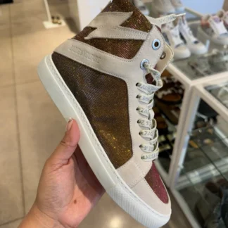 Zapatillas Zadig & Voltaire High Flash originales en Trendstore Chile, cuero blanco con glitter para mujer. Vista frontal de las zapatillas Zadig & Voltaire High Flash originales disponibles en Trendstore Chile con envío a todo Chile. Detalle del cuero blanco y aplicaciones glitter de las zapatillas Zadig & Voltaire High Flash en Trendstore Chile. Vista lateral de las zapatillas Zadig & Voltaire High Flash con cierre lateral y detalle de rayo, compra segura en Chile. Textura premium de las zapatillas Zadig & Voltaire High Flash originales para mujer disponibles en Trendstore Chile. Zapatillas urbanas de cuero Zadig & Voltaire High Flash originales con envío a todo Chile desde Trendstore Chile. Detalle de la lengüeta grabada y ojales metálicos de las zapatillas Zadig & Voltaire High Flash originales en Trendstore Chile. Zapatillas Zadig & Voltaire High Flash premium para mujer, producto original con compra segura y despacho a todo Chile.