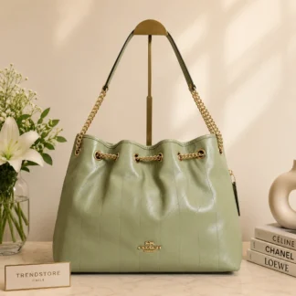 Cartera Coach Evelyn Shoulder Bag acolchada de cuero dorado y pistacho original en Trendstore Chile. Vista frontal de la cartera Coach Evelyn de cuero premium con diseño acolchado y envío a todo Chile. Detalle del cuero brillante y acolchado de la Coach Evelyn Shoulder Bag disponible en Trendstore Chile. Vista lateral de la cartera Coach Evelyn original para mujer con compra segura en Chile. Interior de la cartera Coach Evelyn con cierre superior y bolsillo interno, producto original en Trendstore Chile. Cartera de hombro Coach Evelyn de cuero premium para mujer con despacho a todo Chile desde Trendstore Chile. Textura acolchada y acabado brillante de la Coach Evelyn Shoulder Bag original disponible en Trendstore Chile. Cartera Coach Evelyn original para mujer, compra segura, envío a todo Chile y diseño exclusivo disponible en Trendstore Chile.