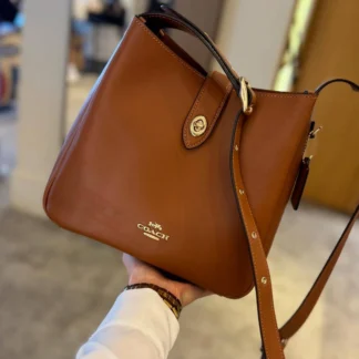 Cartera Coach Hadley Convertible Crossbody Gold Tan de cuero original disponible en Trendstore Chile. Vista frontal de la Coach Hadley Gold Tan de cuero con cierre Turnlock y compra segura en Chile. Detalle del cuero de grano liso de la cartera Coach Hadley Convertible Crossbody original. Vista lateral de la Coach Hadley Gold Tan con correa ajustable para hombro o crossbody. Interior de la cartera Coach Hadley con bolsillo de cremallera disponible en Trendstore Chile. Cartera Coach Hadley de cuero original para mujer con despacho y envío a todo Chile. Detalle del cierre Turnlock y acabados premium de la Coach Hadley Gold Tan original. Coach Hadley Convertible Crossbody Gold Tan original, compra segura y envío a todo Chile desde Trendstore Chile.
