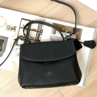 Cartera Coach Emory Top Handle de cuero negro original disponible en Trendstore Chile. Vista frontal de la Coach Emory negra de cuero con herrajes Gunmetal y compra segura en Chile. Detalle del cuero negro premium de la cartera Coach Emory Top Handle original en Trendstore Chile. Vista lateral de la Coach Emory de cuero negro con correa desmontable y envío a todo Chile. Interior de la cartera Coach Emory negra con bolsillos organizadores disponible en Trendstore Chile. Cartera Coach Emory de cuero negro original para mujer con asa superior y correa crossbody. Detalle del cierre Pushlock y herrajes Gunmetal de la Coach Emory negra original. Coach Emory Top Handle de cuero negro original, compra segura y envío a todo Chile desde Trendstore Chile
