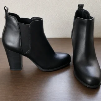 Botines Michael Kors Evaline de tacón negros originales disponibles en Trendstore Chile. Vista frontal de los botines Michael Kors Evaline negros para mujer con punta redonda. Vista lateral de los botines Michael Kors Evaline con tacón bloque y diseño hasta el tobillo. Detalle de la parte superior y acabado premium de los botines Michael Kors Evaline negros. Detalle del tacón bloque y suela de goma de los botines Michael Kors originales. Botines Michael Kors Evaline negros originales para mujer con compra segura y envío a todo Chile. Detalle del tirador posterior de los botines Michael Kors Evaline disponibles en Trendstore Chile. Michael Kors Evaline Heeled Booties negros originales, calzado premium con despacho a todo Chile.