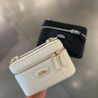 Cartera Marc Jacobs The Everyday Vanity Bag Cloud White de cuero original disponible en Trendstore Chile. Vista frontal de la Marc Jacobs Vanity Bag blanca con detalle de logo y compra segura en Chile. Detalle del cuero de la Marc Jacobs The Everyday Vanity Bag Cloud White original. Vista lateral de la cartera Marc Jacobs blanca con asa superior y correa desmontable. Interior de la Marc Jacobs Everyday Vanity Bag con cierre de cremallera disponible en Trendstore Chile. Cartera Marc Jacobs Cloud White original para mujer con diseño vanity y envío a todo Chile. Detalle del logo y acabados premium de la Marc Jacobs Everyday Vanity Bag. Marc Jacobs The Everyday Vanity Bag Cloud White original, compra segura y despacho a todo Chile desde Trendstore Chile.
