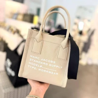 Cartera Marc Jacobs Small Standard Supply Tote original disponible en Trendstore Chile. Vista frontal de la tote Marc Jacobs Small Canvas con dos asas y compra segura en Chile. Detalle del textil y acabados de la Marc Jacobs Standard Supply Tote original. Vista lateral de la cartera Marc Jacobs Small con correa ajustable para hombro o crossbody. Detalle del cierre superior con cremallera de la Marc Jacobs Small Standard Supply Tote. Cartera Marc Jacobs Small Tote original para mujer con detalles en cuero sintético y envío a todo Chile. Detalle de las asas y estructura de la Marc Jacobs Standard Supply Tote disponible en Trendstore Chile. Marc Jacobs Small Canvas Standard Supply Tote original, compra segura y despacho a todo Chile desde Trendstore Chile.