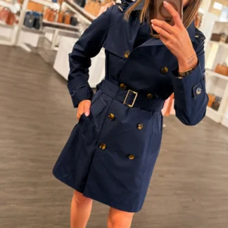 Trench coat Michael Kors para mujer con cinturón original disponible en Trendstore Chile. Vista frontal de la gabardina Michael Kors con cinturón y cierre de botones. Detalle del tejido de poliéster y acabados del trench coat Michael Kors original. Vista lateral de la gabardina Michael Kors con cinturón para definir la silueta femenina. Trench coat Michael Kors para mujer ideal para looks elegantes y de entretiempo. Gabardina Michael Kors original con compra segura y envío a todo Chile desde Trendstore Chile. Detalle del cinturón y cierre frontal con botones del trench coat Michael Kors. Trench coat Michael Kors de poliéster original para mujer, exclusivo y disponible en Trendstore Chile.