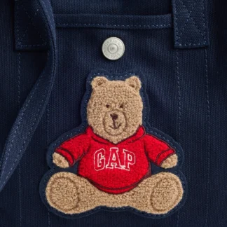 # **GAP MINI BRANNAN BEAR CANVAS FAVORITE TOTE** ## DESCRIPCIÓN CORTA La **GAP Mini Brannan Bear Canvas Favorite Tote** combina un diseño compacto con la practicidad de una cartera tote. Confeccionada en lona de algodón suave y liviana, cuenta con doble asa, correa larga desmontable y múltiples bolsillos para organizar tus esenciales. Su tamaño mini y su estilo casual la convierten en una opción versátil para acompañarte todos los días. ## COPY PARA INSTAGRAM / REEL **Pequeña, práctica y demasiado linda para pasar desapercibida. 🧸🤎** La **Mini Brannan Bear Tote de GAP** es ese bolso que puedes llevar de mil maneras según tu look. 👜 Lona de algodón suave y liviana ✨ Doble asa y correa larga 🤎 Tres bolsillos exteriores 🔑 Bolsillo interior 💫 Llévala en la mano, al hombro o cruzada Un diseño mini, pero con espacio para tus esenciales y toda la onda casual de GAP. **Tu nueva compañera para todos los días.** ## DESCRIPCIÓN LARGA SEO La **GAP Mini Brannan Bear Canvas Favorite Tote** es una cartera tipo tote de tamaño compacto, diseñada para combinar comodidad, funcionalidad y estilo casual. Está confeccionada en **lona de algodón suave y liviana**, ideal para acompañarte en tus actividades cotidianas. Su diseño incorpora doble asa y una correa larga que permite llevarla de diferentes formas: en la mano, al hombro, sobre el codo o cruzada como bandolera. Para una mejor organización, cuenta con **tres bolsillos exteriores abiertos y un bolsillo interior**, perfectos para mantener tus objetos esenciales accesibles. Además, incorpora un cierre tipo broche a presión (*snap closure*) que ayuda a mantener el contenido en su lugar. Sus dimensiones compactas hacen que sea fácil de combinar con looks casuales, urbanos y relajados. La línea Brannan Bear aporta el encanto característico de GAP, convirtiéndola en una alternativa práctica para quienes buscan una cartera liviana y versátil. Encuentra la **GAP Mini Brannan Bear Canvas Favorite Tote** en Trendstore Chile, según disponibilidad de stock. ## CARACTERÍSTICAS - Marca: **GAP** - Modelo: **Mini Brannan Bear Canvas Favorite Tote** - Cartera tipo tote compacta. - Confeccionada en lona de algodón. - Tejido suave y liviano. - Doble asa superior. - Correa larga para diferentes formas de uso. - Tres bolsillos exteriores abiertos. - Un bolsillo interior abierto. - Cierre con broche a presión. - Se puede llevar en la mano, al hombro, sobre el codo o cruzada. - Diseño casual y versátil. ## MATERIALES / COMPOSICIÓN - **Lona de algodón suave y liviana.** *La composición porcentual exacta no está especificada en la información proporcionada.* ## MEDIDAS - Largo: **8,5" / 21,6 cm** - Alto: **8,6" / 21,8 cm** - Profundidad: **3" / 7,6 cm** ## ASA - Caída de las asas: **3,5" / 8,9 cm** ## CORREA - Largo: **21" / 53,3 cm** - Permite llevarla al hombro o cruzada. ## COLOR No especificado en la información proporcionada. ## MODELO / PRODUCT NUMBER **Mini Brannan Bear Canvas Favorite Tote — Producto n.º 1181613** ## PÚBLICO Unisex. ## DISPONIBILIDAD Disponible en **Trendstore Chile**, según disponibilidad de stock. ## SEO PARA IMÁGENES 1. GAP Mini Brannan Bear Canvas Favorite Tote 2. cartera tote mini GAP de lona 3. GAP Mini Canvas Tote Bag original 4. bolso GAP de algodón con doble asa 5. cartera GAP pequeña con correa larga 6. mini tote GAP para uso diario 7. bolso GAP con bolsillos exteriores 8. GAP Brannan Bear Canvas Tote Chile 9. cartera GAP casual para mujer 10. bolso GAP original Trendstore Chile ## PALABRAS CLAVE SEO GAP Mini Brannan Bear Canvas Favorite Tote, GAP Mini Tote Bag, cartera GAP mini, bolso GAP de lona, tote GAP de algodón, cartera GAP con correa larga, bolso GAP pequeño, GAP Canvas Tote, cartera casual GAP, GAP original Chile, Trendstore Chile. ## META DESCRIPTION Descubre la GAP Mini Brannan Bear Canvas Favorite Tote en Trendstore Chile. Tote mini de algodón con doble asa, correa larga y bolsillos para organizar tus esenciales.